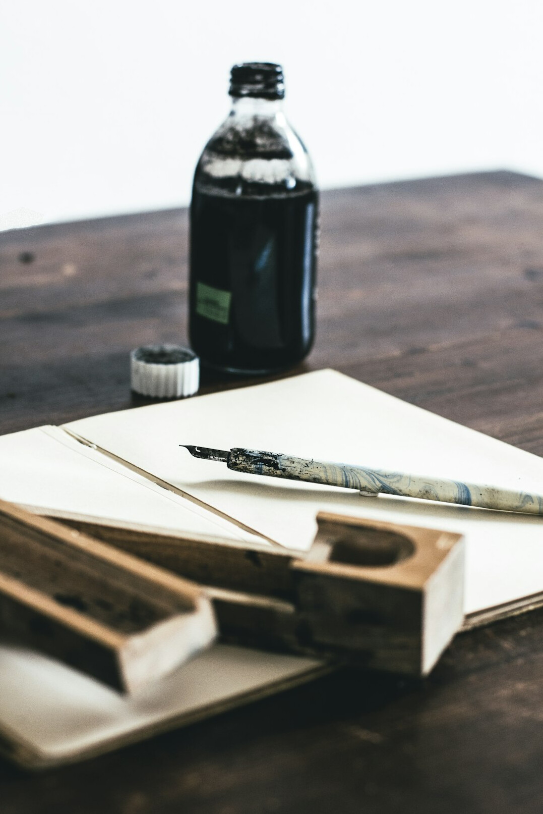 Old wooden desk with pen ink and notebook