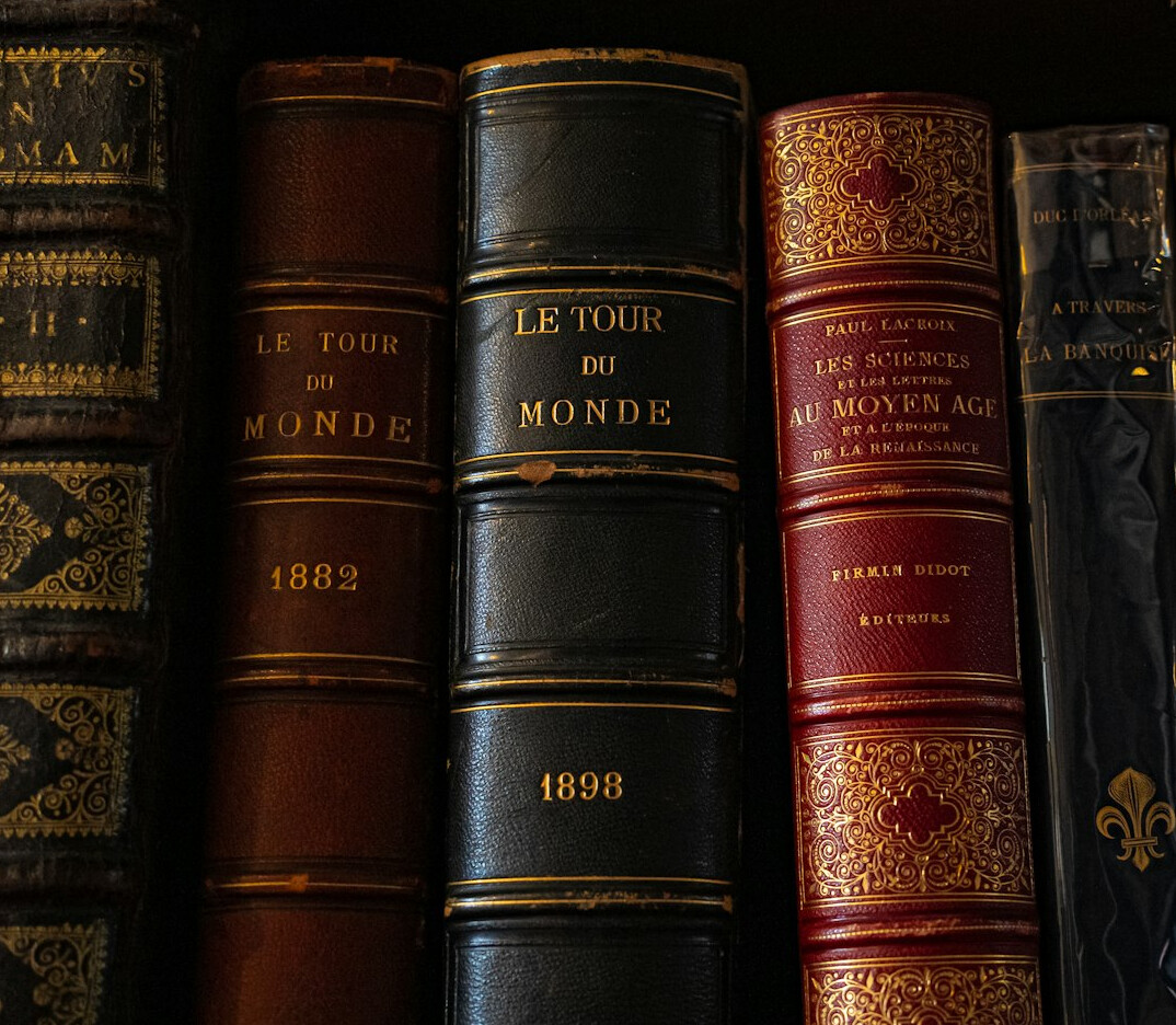 Close-up of old leather bound books stacked together