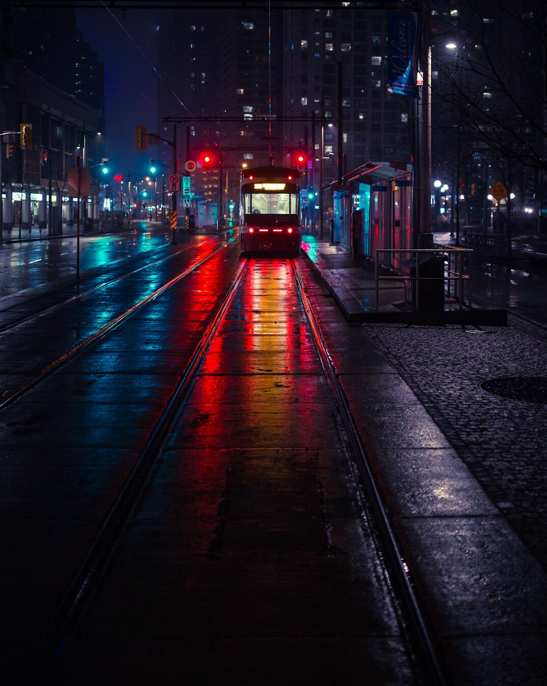 Empty rainy city street at night with streetlights